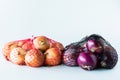 Mesh bags of onions  against a white background. Royalty Free Stock Photo