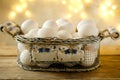 mesh vintage metal basket with fresh white chicken eggs on wooden table, valuable food product, Easter culinary traditions, close- Royalty Free Stock Photo