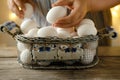 mesh vintage metal basket with fresh white chicken eggs on wooden table, valuable food product, Easter culinary traditions, close- Royalty Free Stock Photo