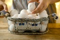 mesh vintage metal basket with fresh white chicken eggs on wooden table, valuable food product, Easter culinary traditions, close- Royalty Free Stock Photo