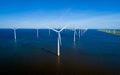 A mesmerizing aerial view of a row of wind turbines swaying gracefully in the ocean breeze