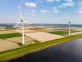 A mesmerizing aerial view of a wind farm in Flevoland, Netherlands, where towering windmills stand gracefully in the
