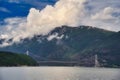 Mesmerizing view of a bridge over the river with a forested mountain on the background