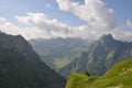 Mesmerizing landscape of a steep slope covered by grass with mountains in the background