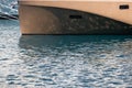 The mesmerizing reflection of the water on the glossy side of a huge yacht anchored, chrome details