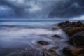 Mesmerizing seascape with wavy water and rocky coast on the gloomy sky background