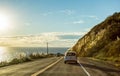 Mesmerizing shot of cars driving on the Route One highway along the sea, in the USA