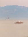 Mesmerizing soft misty morning over the shore with a ship Royalty Free Stock Photo