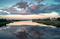 Mirror glossy surface of the Volga river reflects dramatic sunset sky. City of Tver, Russia. Royalty Free Stock Photo