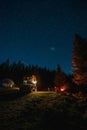 Mesmerizing vertical view of a camping site in the Apuseni Mountains with a starry night sky