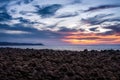 Mesmerizing view of a calm sea with pebble stones on the beach under a dramatic sunset sky Royalty Free Stock Photo