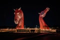 Mesmerizing view of colorful illuminated Kelpies at night in Helix Park, Falkirk Scotland