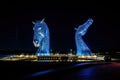 Mesmerizing view of colorful illuminated Kelpies at night in Helix Park, Falkirk Scotland