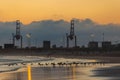 Mesmerizing view of the golden sunset over the factory near the sea Royalty Free Stock Photo