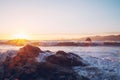 Mesmerizing view of the ocean waves crashing on the rocks near the shore during sunset Royalty Free Stock Photo