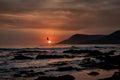 Mesmerizing view of an orange sunset with silhouette of hills on the beach