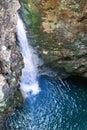 Mesmerizing waterfall inside a mysterious cave with a plunge pool Royalty Free Stock Photo