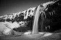 Mesmerizing winter scene of a picturesque waterfall cascading down a rocky mountainside Royalty Free Stock Photo