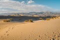 Mesquite Sand Dunes, mountains and cloudy sky background. Death Valley National Park Royalty Free Stock Photo