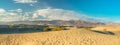 Mesquite Sand Dunes, mountains and cloudy sky background. Death Valley National Park, panorama Royalty Free Stock Photo