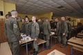 At a mess hall: soldiers standing at set-out tables, praying before having dinner