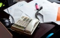 Mess on an office desk, telephone, lots of papers and company documents, simple messy workspace, lots of overwhelming work scene