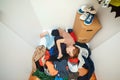 Mess in open wardrobe. Untidy clutter clothing closet. Boy with messy stack of clothes things on floor