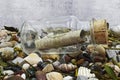 Message in a bottle on a beach with stones and shells. Studio shot Royalty Free Stock Photo