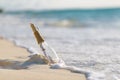 Message in bottle on beach with white sand, in tropical sea. Sunny blue sea horizon Royalty Free Stock Photo