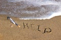 Message in a bottle at the beach and the word help Royalty Free Stock Photo