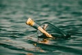 Message in a bottle floating on the ocean waves