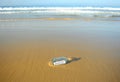 Message in a bottle. Hello! Bottle with greetings on beach. Royalty Free Stock Photo