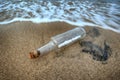 Message in a bottle in the sand of sea beach Royalty Free Stock Photo