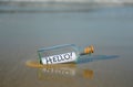 Hello! Bottle with greetings on beach. Message in a bottle Royalty Free Stock Photo