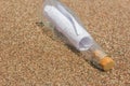 A message in a bottle on the sand. note on salvation, please help Royalty Free Stock Photo