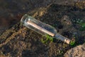 Message in a bottle on a stone covered with seaweed Royalty Free Stock Photo
