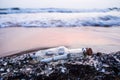 Message in a bottle stuck on the rocks Royalty Free Stock Photo