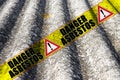 The message `danger asbestos` written on a yellow stripe