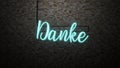 The message Danke neon light on Brick wall bcakground Royalty Free Stock Photo