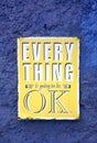 Message of EVERYTHING is going to be OK on the yellow board hanging on the rough blue wall Royalty Free Stock Photo