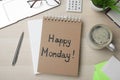 Message Happy Monday written in notebook, office stationery and cup of coffee on wooden  desk, flat lay Royalty Free Stock Photo