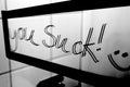 `You suck!` written on a bathroom mirror. Royalty Free Stock Photo