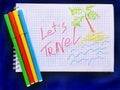 Message Lets Travel on white notebook with color markers. Closeup. Travel concept. Royalty Free Stock Photo