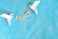 Message of peace. White dove origami carrying word letters in sky blue background. Royalty Free Stock Photo