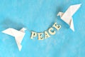 Message of peace. White dove origami carrying word letters in sky blue background. Royalty Free Stock Photo