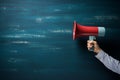 Message space Megaphone and hand displayed on blue chalkboard backdrop