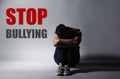 Message STOP BULLYING and sad man sitting