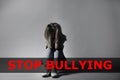 Message STOP BULLYING and sad woman sitting