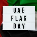 Message with text UAE FLAG DAY on United Arab Emirates waving flag made from silk material. Independence Commemoration Royalty Free Stock Photo