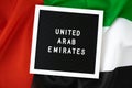 Message UNITED ARAB EMIRATES on background waving flag of UAE. National holiday, Independence Commemoration Day Muslim Royalty Free Stock Photo